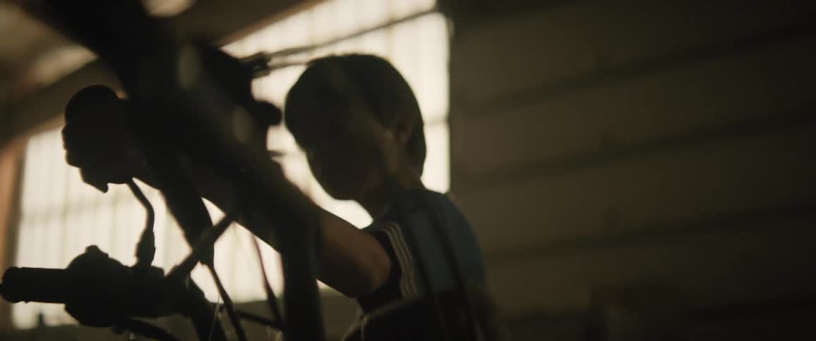 Little boy passing his hand on a rear view mirror inside the warehouse