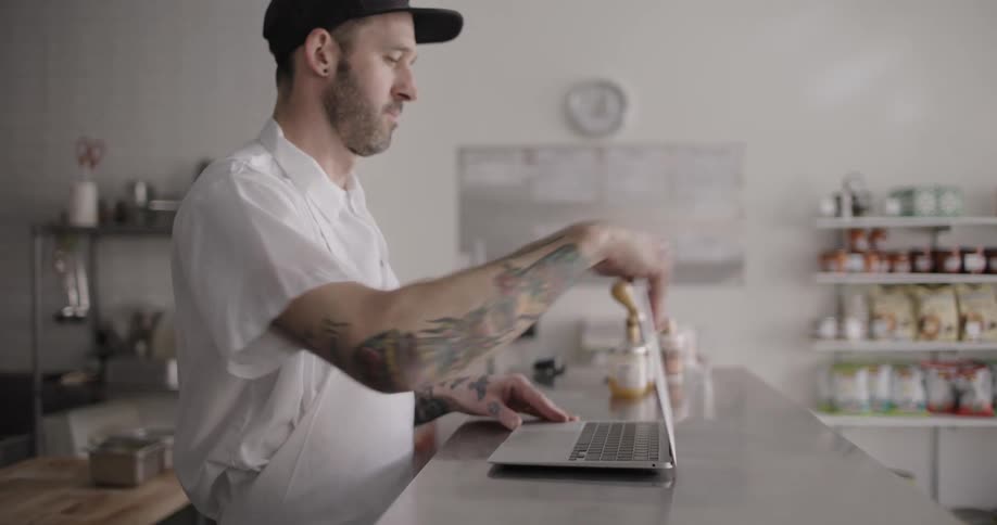 A man opens a laptop and types on it