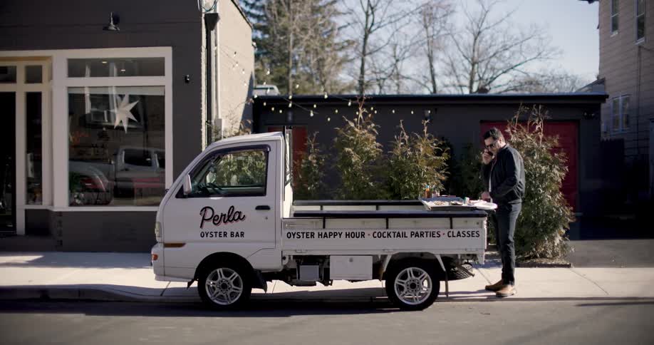 Standing talking on the phone in front of his food truck