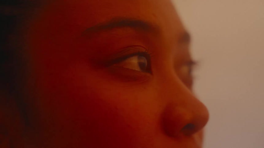 Close up of the eyes of a young Asian woman under a soft yellow light