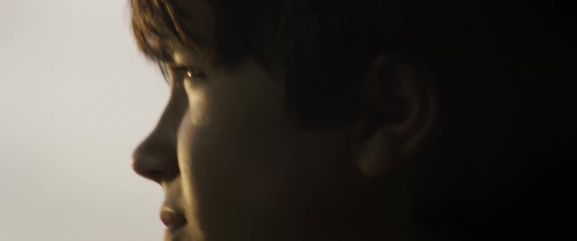 A teenage boys face and his hair moving in the wind
