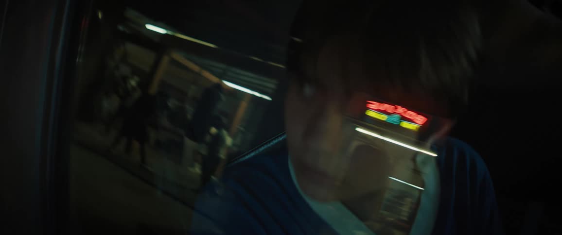 Teen looking outdoor while seated in a parked vehicle at night