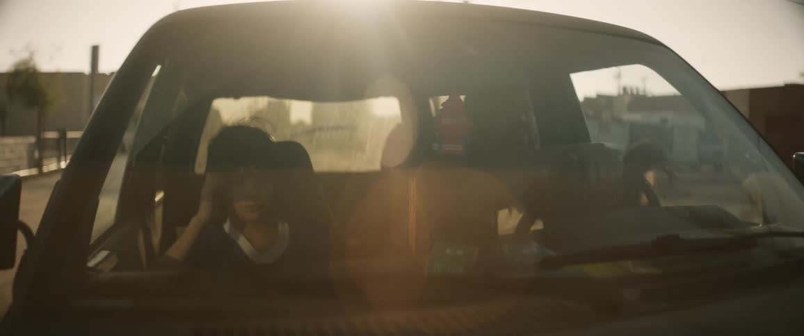 Son holds the steering wheel of a car for a short moment