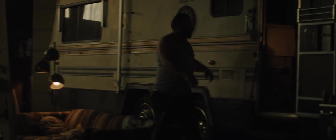 A man is walking and then he enters the door of a trailer that is parked