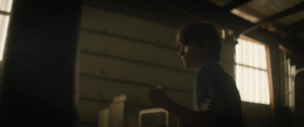 Boy inside a warehouse throwing boxing punches on a bag