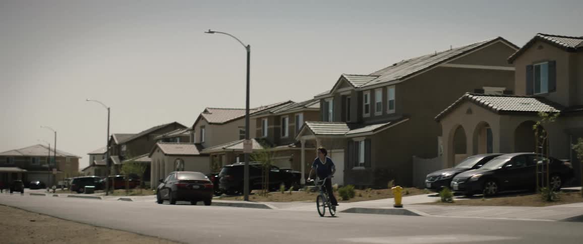 A boy riding a bicycle on a neighborhood street