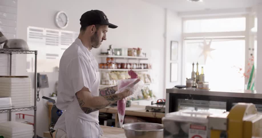 A chef puts an ingredient in a plastic bag