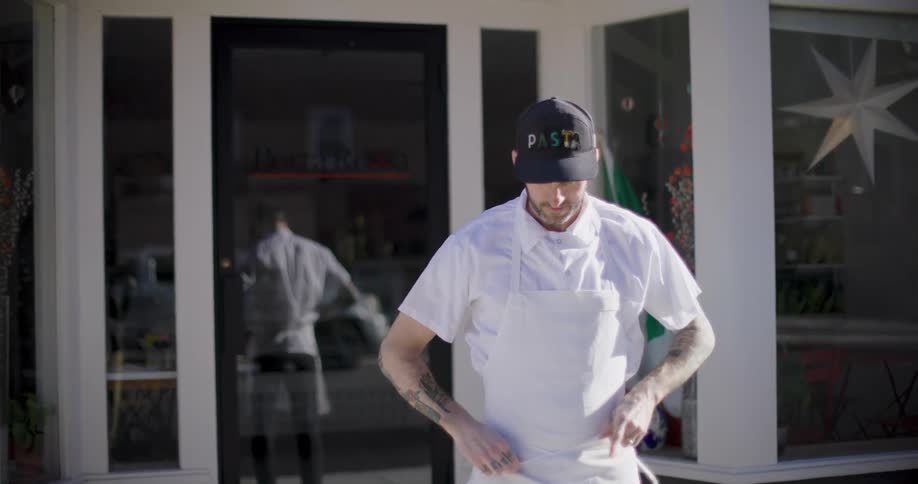Man putting on his white apron being the chef of restaurant
