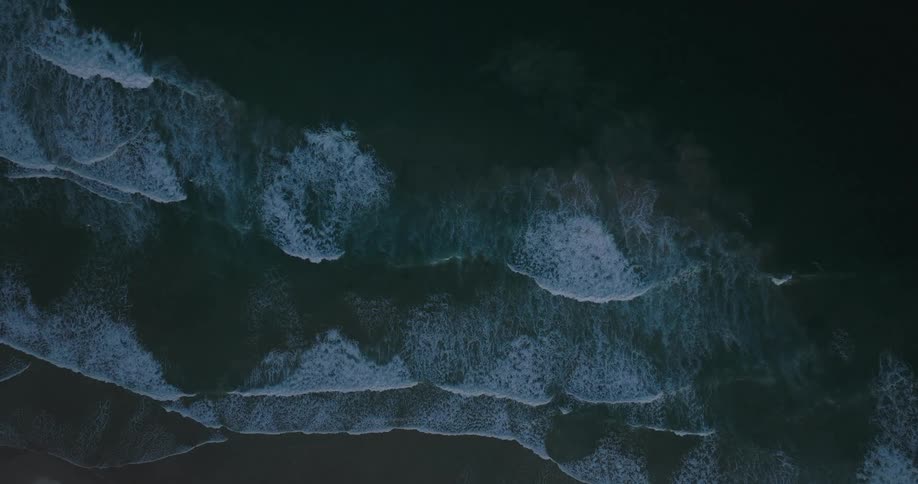 Aerial of sea waves rolling into the shoreline