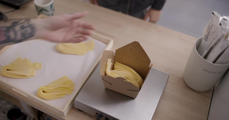 Person placing raw dough inside a box