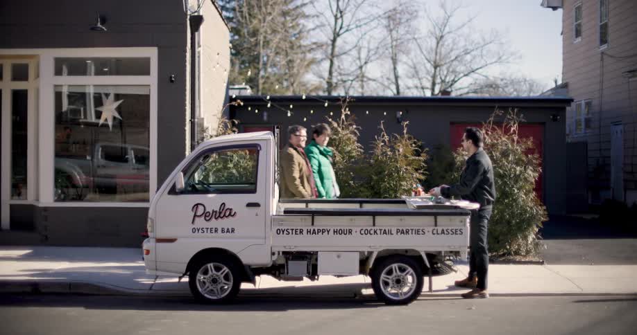 Man in a small van on the street and two other people arriving and me greeting