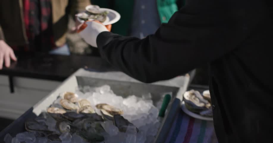 Man with gloves preparing a dish with oysters for the customer