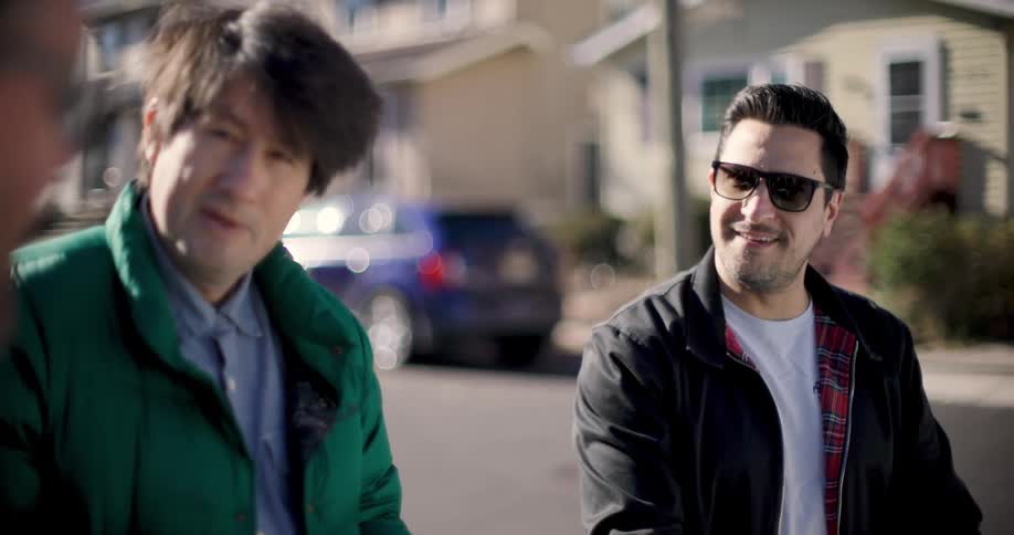 Portrait of three friends smiling next to the street talking