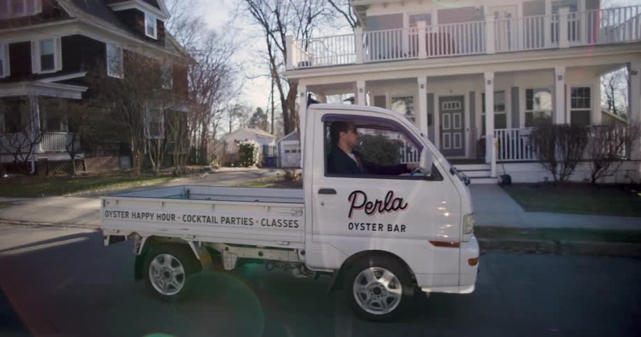 Man drives small truck belonging to restaurant along residential street