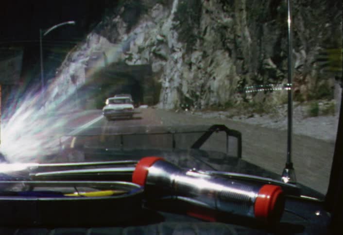 Cars entering a tunnel as seen through a moving windshield