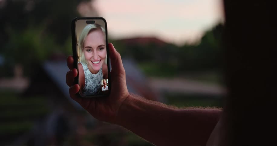 A happy woman on the screen of a phone at sunset