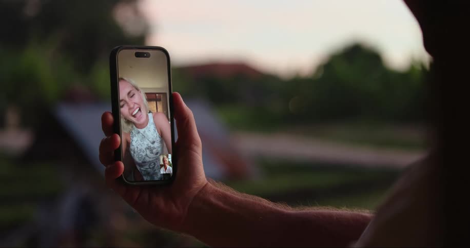 Man makes video call on smartphone with a blonde woman laughing