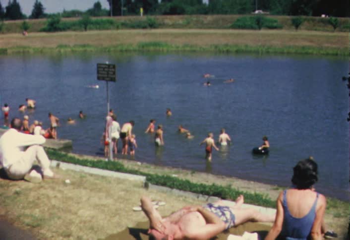 Swimmers splash and wade in a small lake