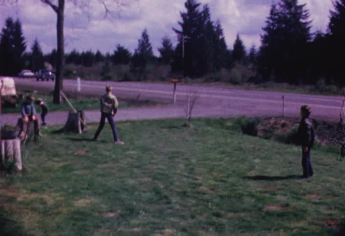 Children are playing catch in a yard during the day