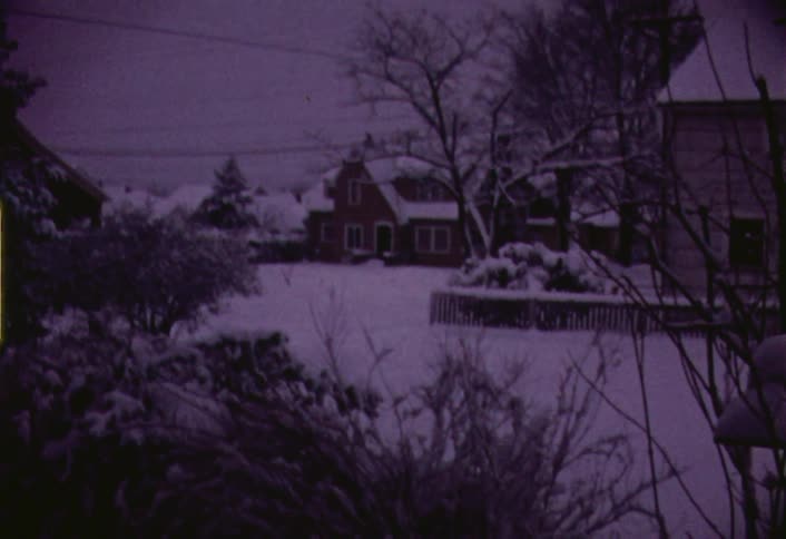 Snow covers the road as a truck passes by
