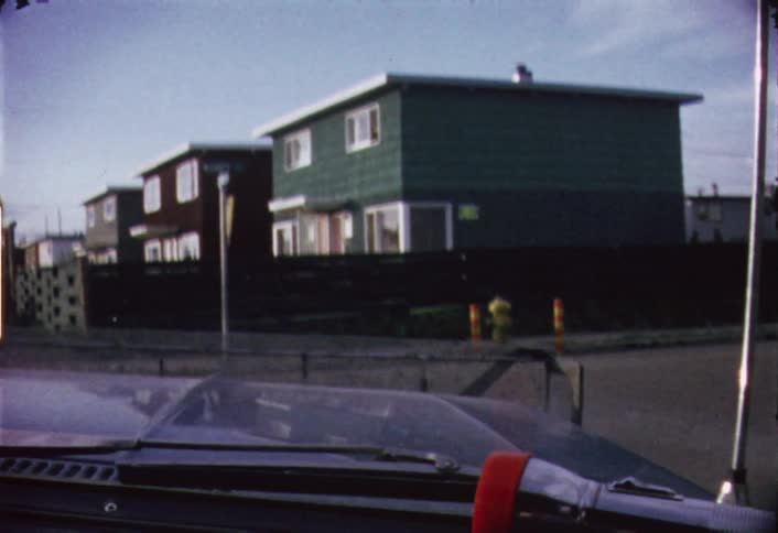 A row of buildings can be seen from a car as it passes by