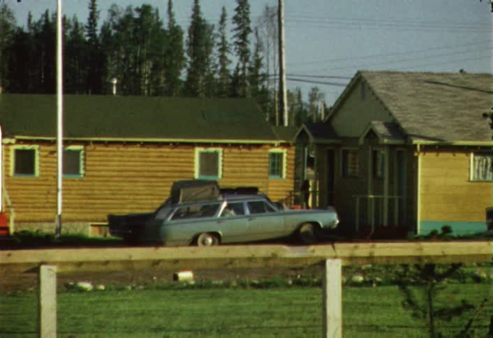 A station wagon loaded with gear is sitting in front of a house