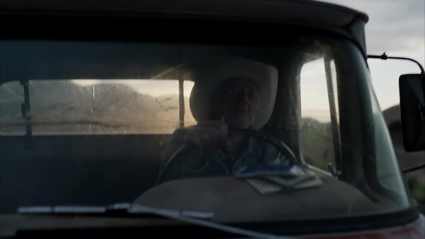 An elderly man drives a truck