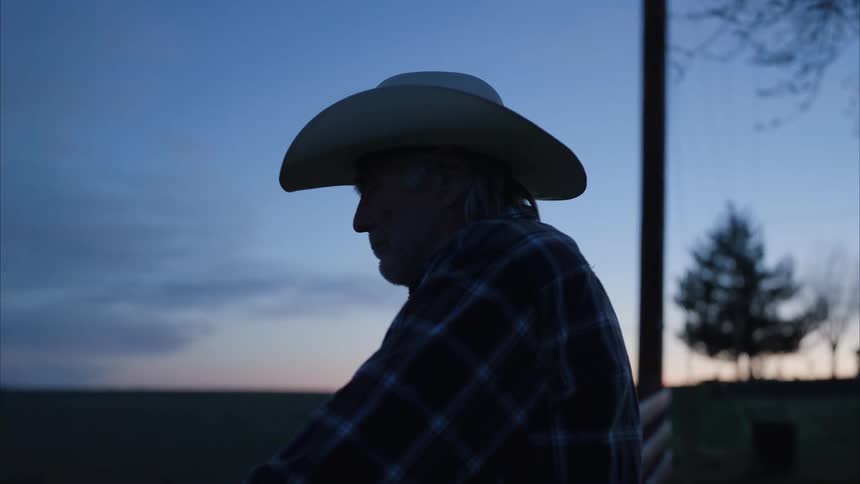 A man sitting outdoors at sunset