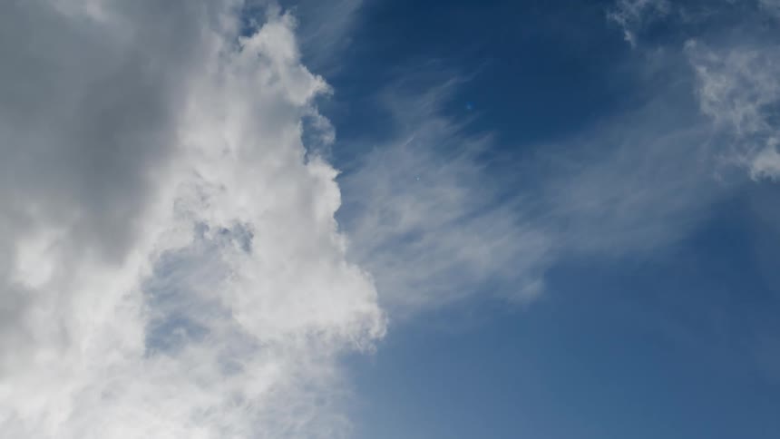 A view of the blue sky where some white clouds are passing by