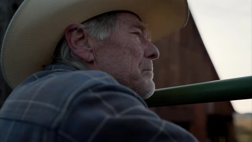 A sad old cowboy stares into the distance