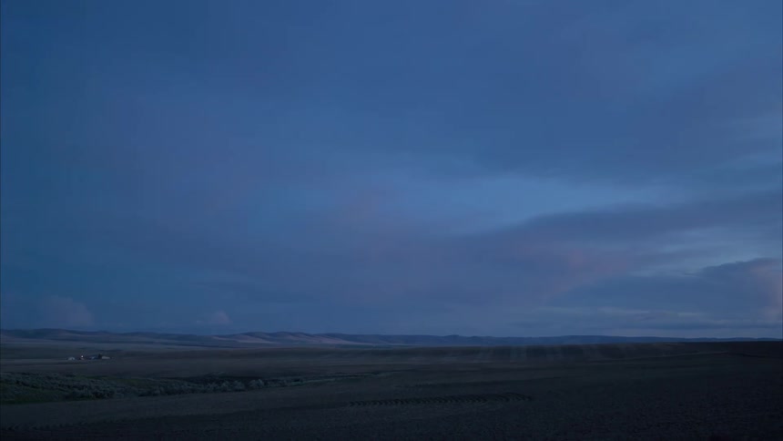 A farm sits on a large plain