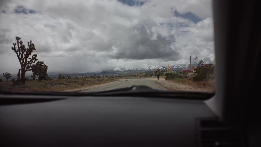 View from inside the cars windshield stopped on a street in the middle of a desert