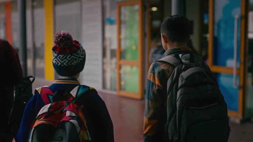 School kids with backpacks walk through the school building