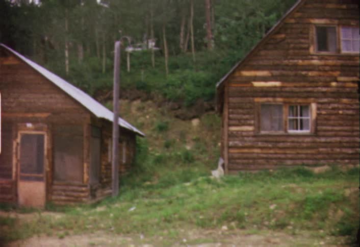Panning view of large log cabins on a hillside