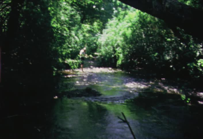 A man is fishing in a peaceful stream