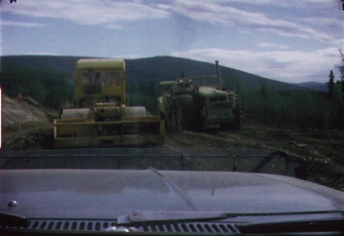 Men working on heavy machinery in a field