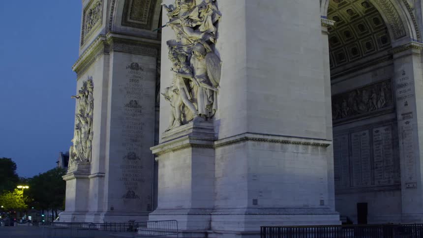 Traffic drives along nearby road near arc de triomphe at night