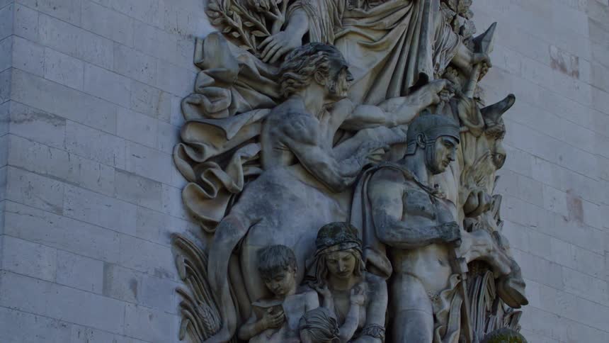 A detailed stone sculpture is attached to a building at daytime
