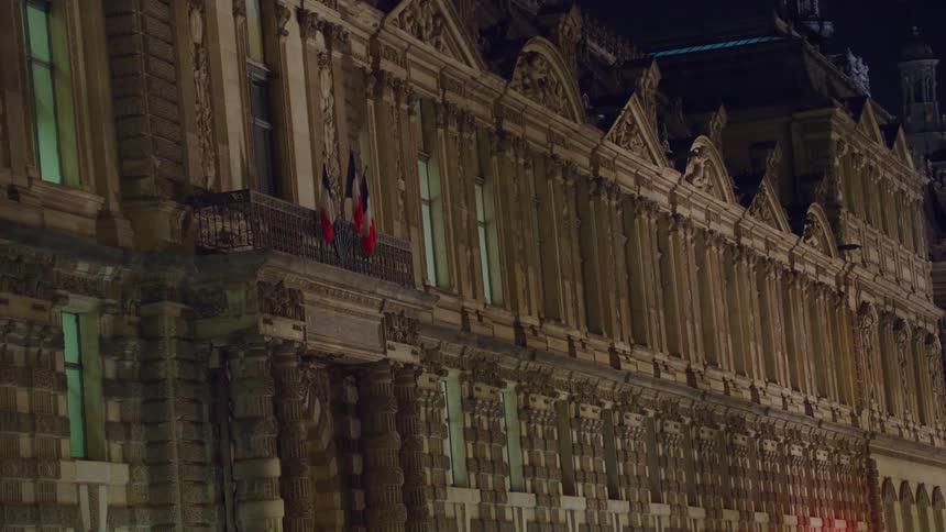 Night scene of a welllit elegant building facade in an european city