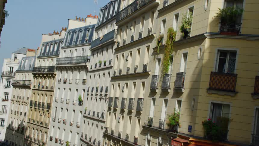 Plants grow on several of the narrow balconies of apartment buildings