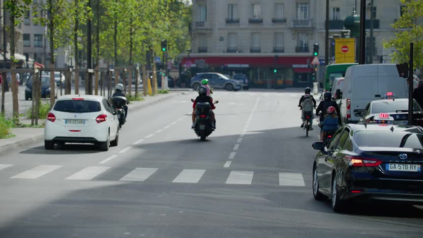 Cars and motorcycles driving on the city streets at daytime