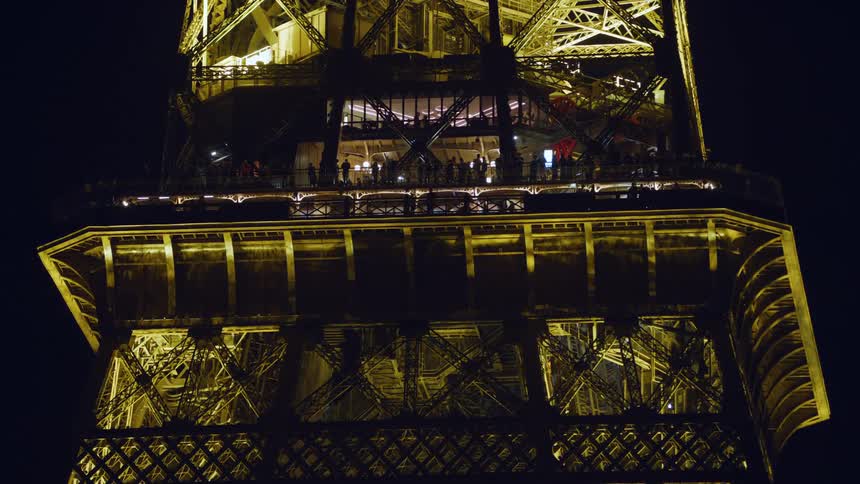 Close up of the exterior of the eiffel tower illuminated at night