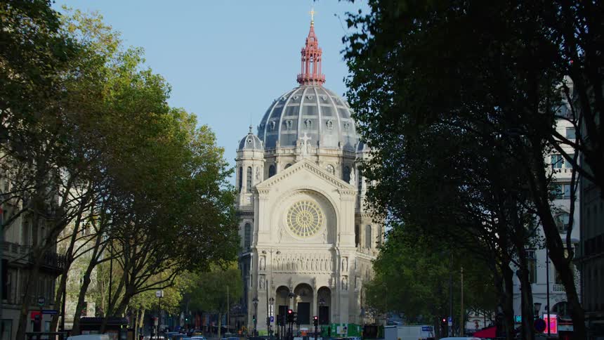 Traffic moves along streets near domed cathedral