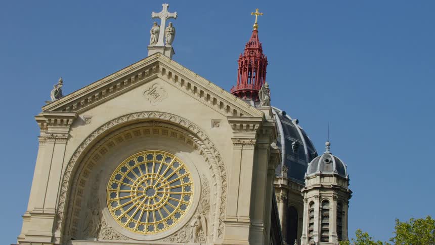 Facade of a cathedral with the name on a cross top in the city during a blue sky day