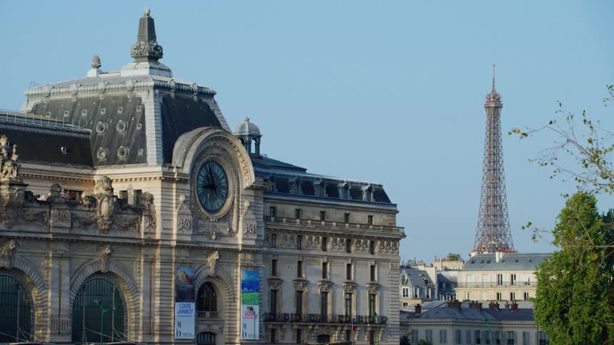 Landscape of the city of france with a view of a gothic building and the end of the eiffel tower on a cloudless blue sky day