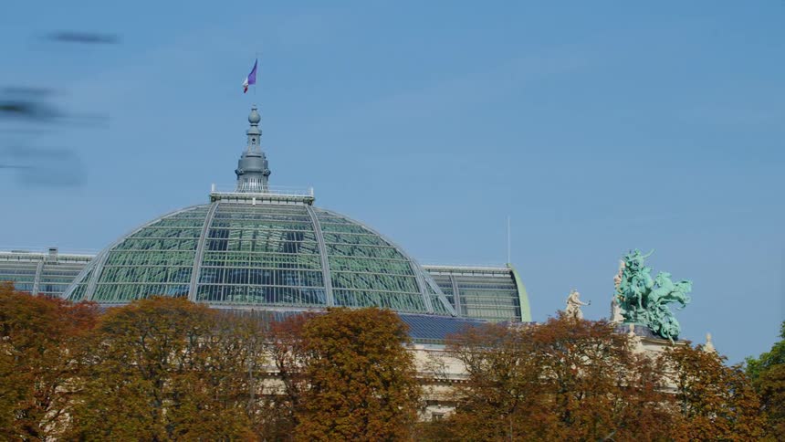 A flag flies at the top of a building in a city