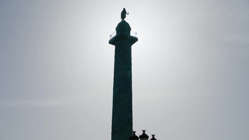 A tall tower with a sculpture of a man on the top