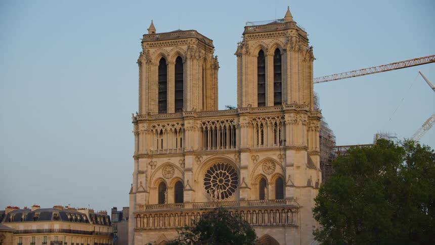 A view of the notredame cathedral and a crane in paris on a clear day