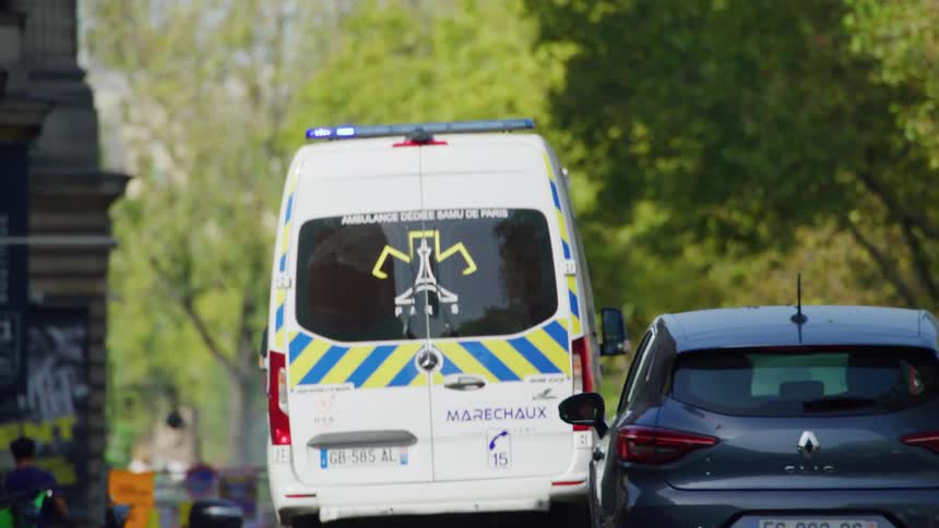 A french ambulance with emergency lights on driving on a city road