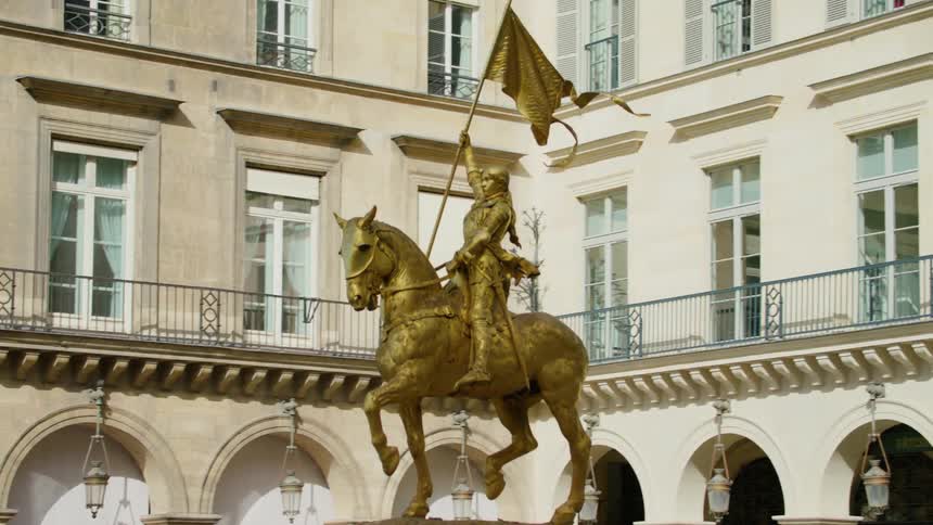 A gold statue is in the middle of all the buildings